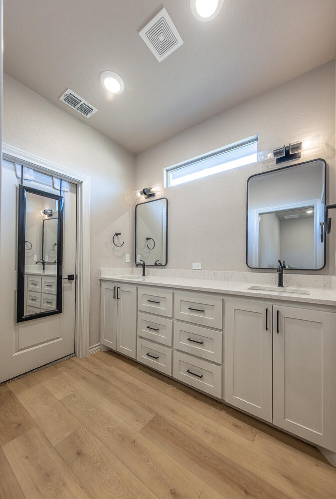 6913 15th Street Lubbock, TX 79416 - Photo 13 of 27 a spacious bathroom with double vanity sink and a mirror