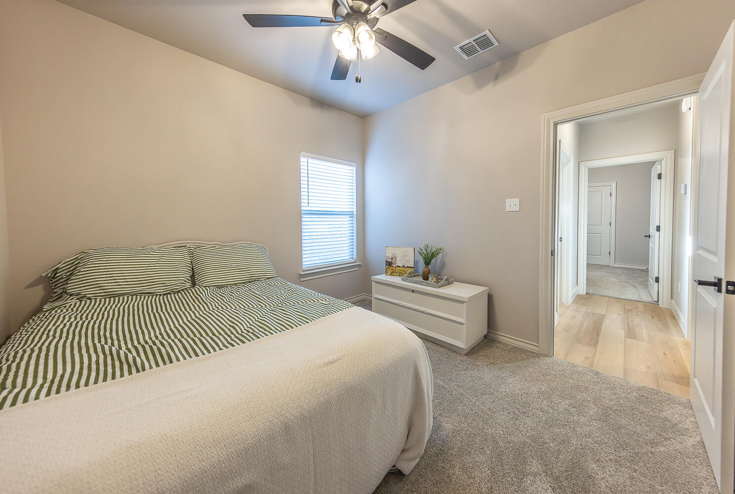 6913 15th Street Lubbock, TX 79416 - Photo 17 of 27 a bedroom with a bed and a chandelier