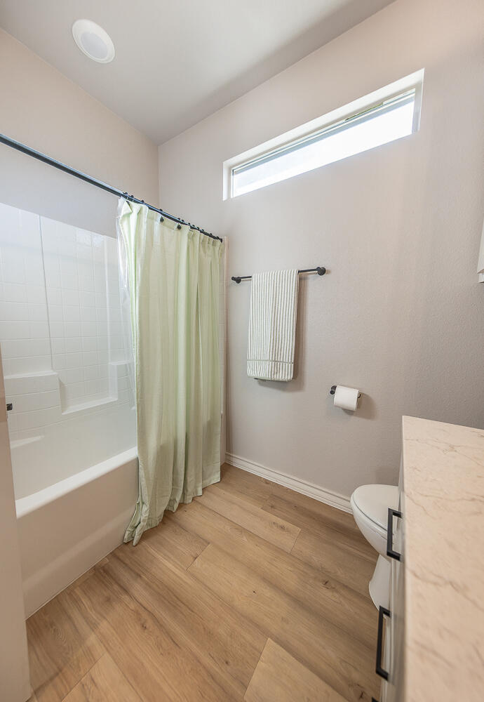6913 15th Street Lubbock, TX 79416 - Photo 19 of 27 a bathroom with a shower and a toilet