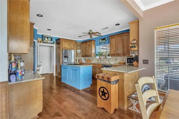 a kitchen that has a lot of white cabinets and stainless steel appliances