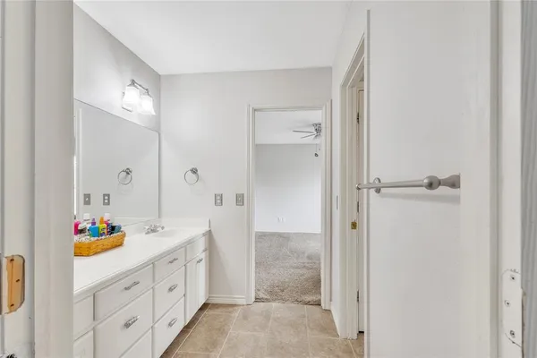 an empty room with a ceiling fan and carpet