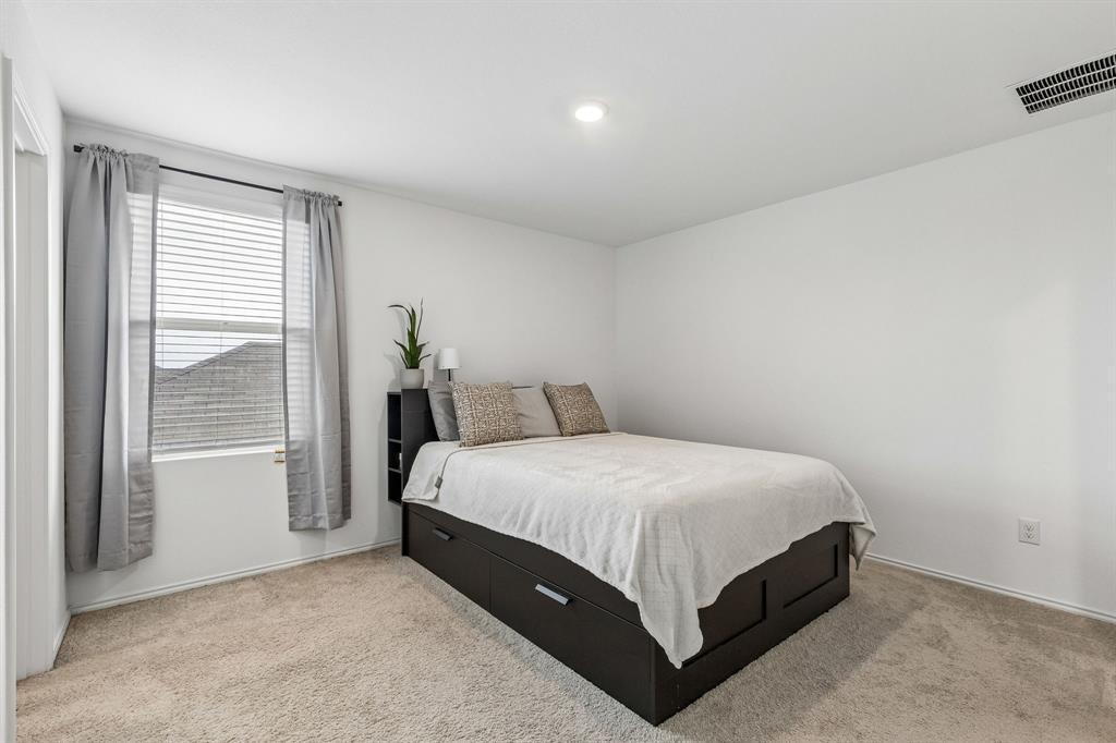 3044 Harper Street Little Elm, TX 75068 - Photo 16 of 24 a bed sitting in a spacious bedroom next to a window