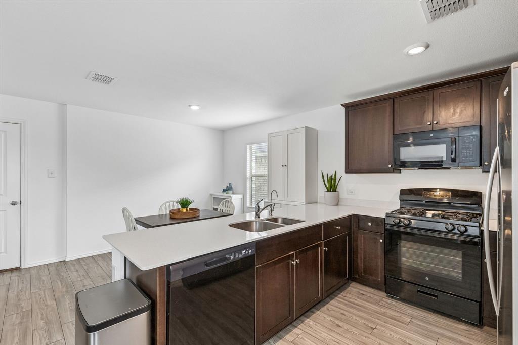 3044 Harper Street Little Elm, TX 75068 - Photo 10 of 24 a kitchen with a sink stove top oven and cabinets