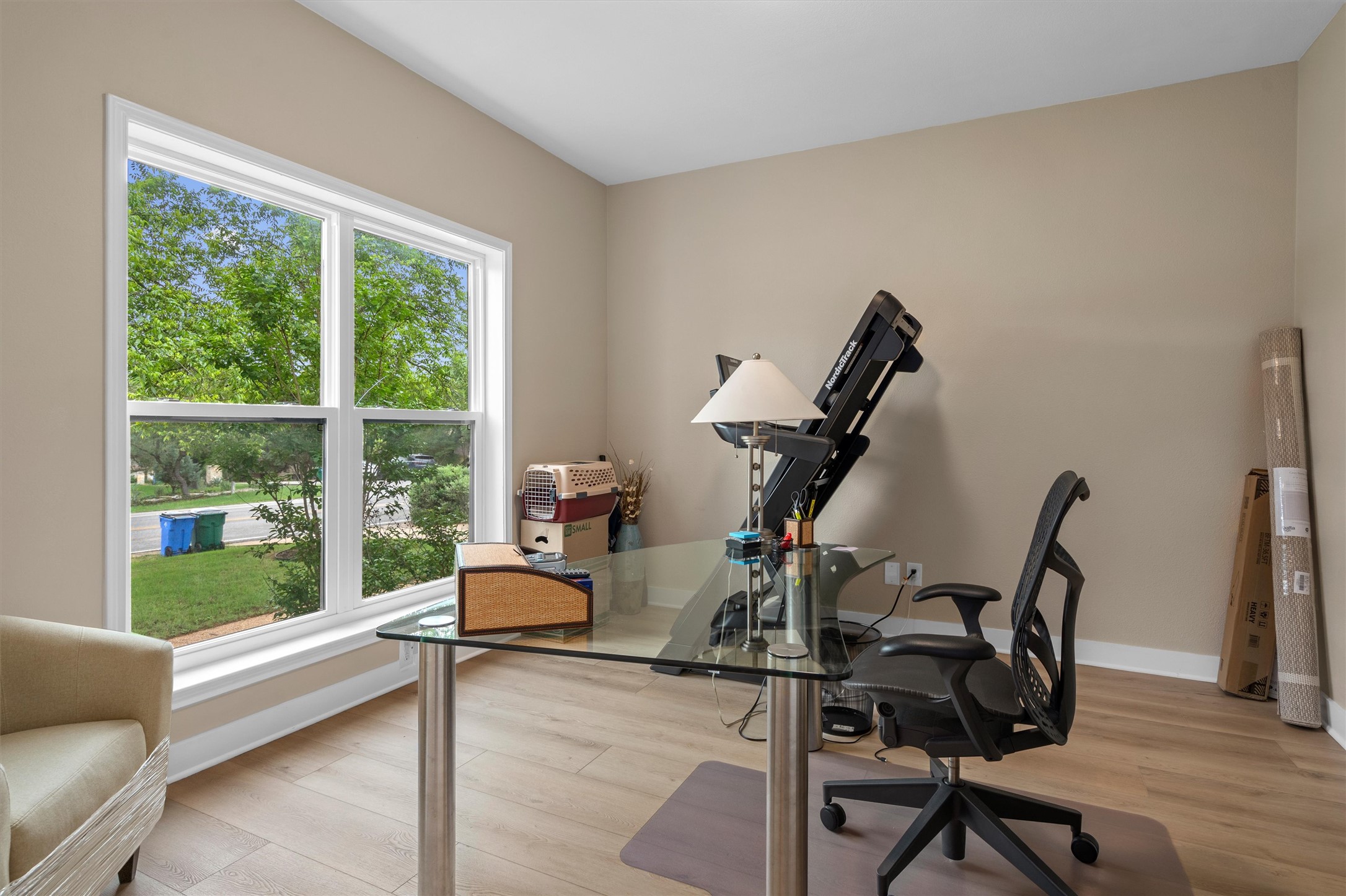 307 Hurst Creek Road Austin, TX 78734 - Photo 14 of 40 Room featuring a large window with white trim, wood-finish flooring, and neutral wall paint