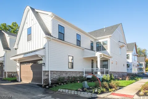 a view of a white house next to a yard