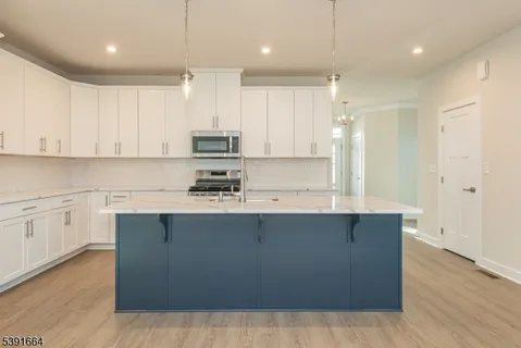 a kitchen with stainless steel appliances granite countertop a sink a stove and a refrigerator