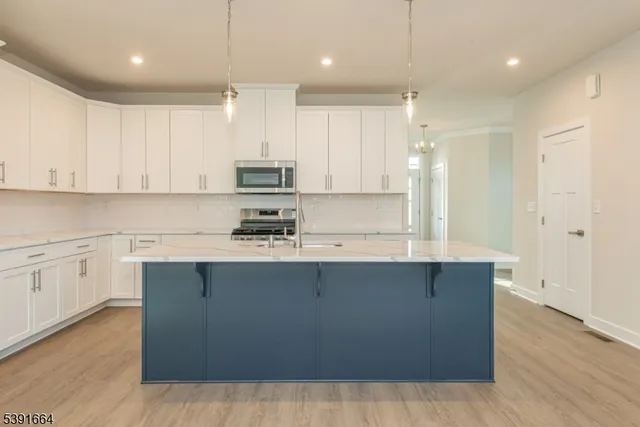 a kitchen with stainless steel appliances granite countertop a sink a stove and a refrigerator