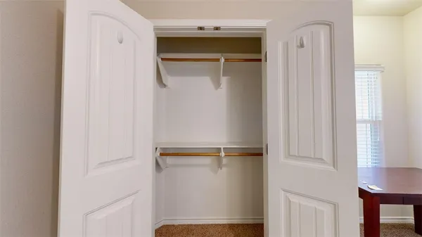 an empty room with a window and a ceiling fan
