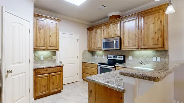 a kitchen with stainless steel appliances granite countertop a stove microwave and cabinets