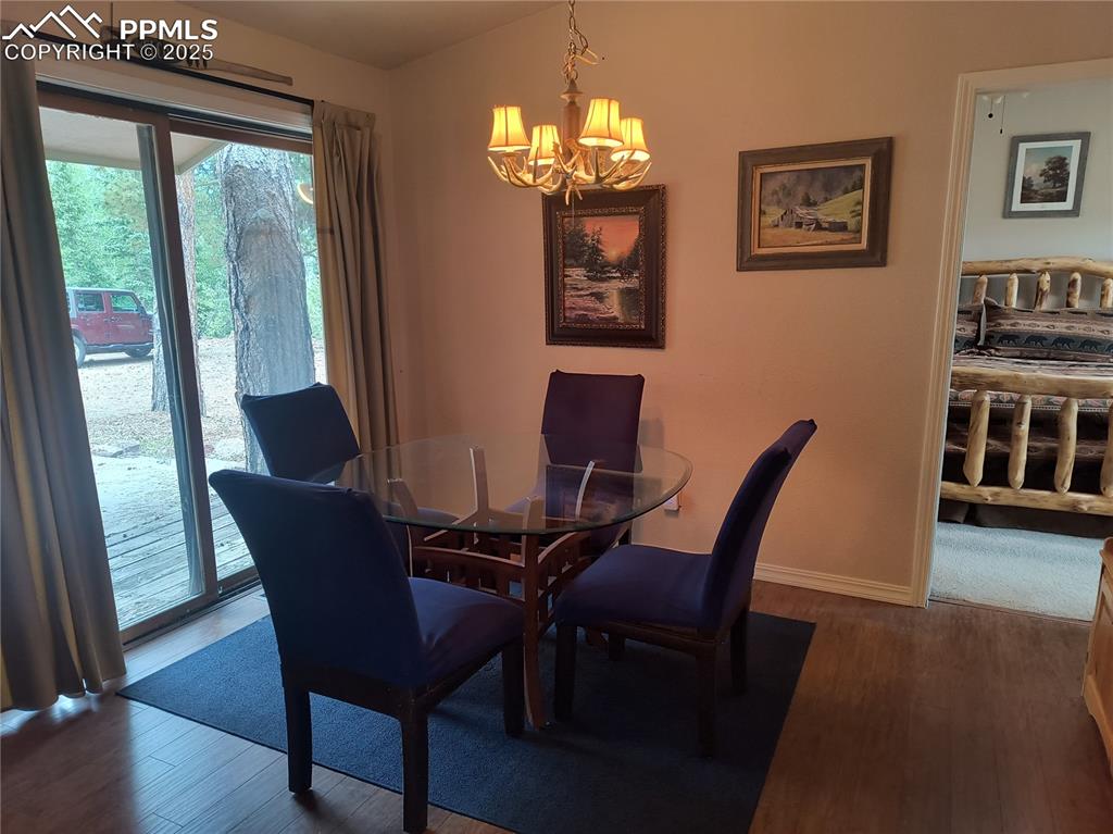 237 Blue Spruce Road Divide, CO 80814 - Photo 21 of 47 a view of a dining room with furniture a chandelier and wooden floor