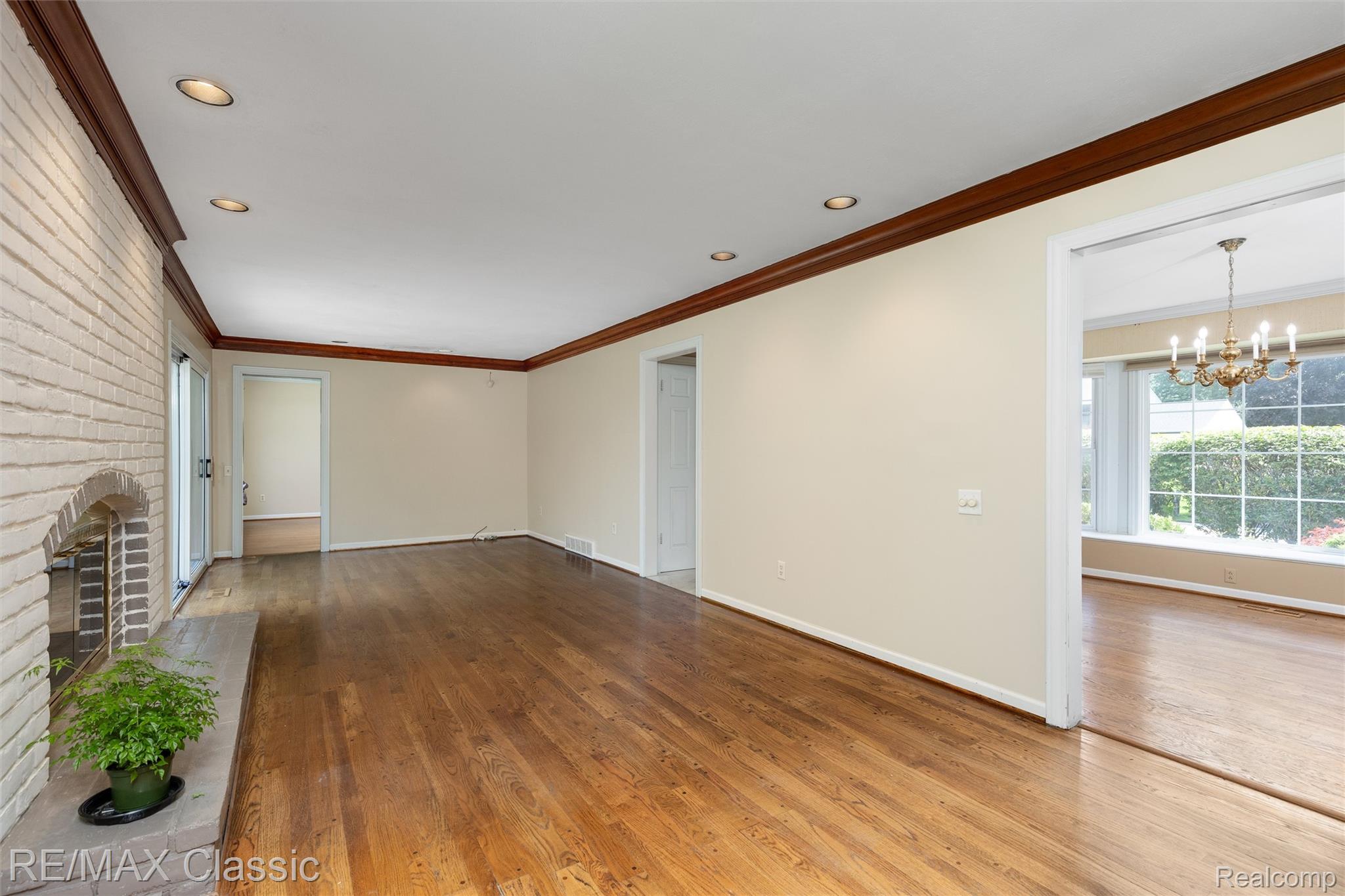 4268 Covered Bridge Road Bloomfield Hills, MI 48302 - Photo 7 of 35 Spacious interior featuring wood-finish flooring, a brick fireplace with a hearth, recessed lighting, and crown molding