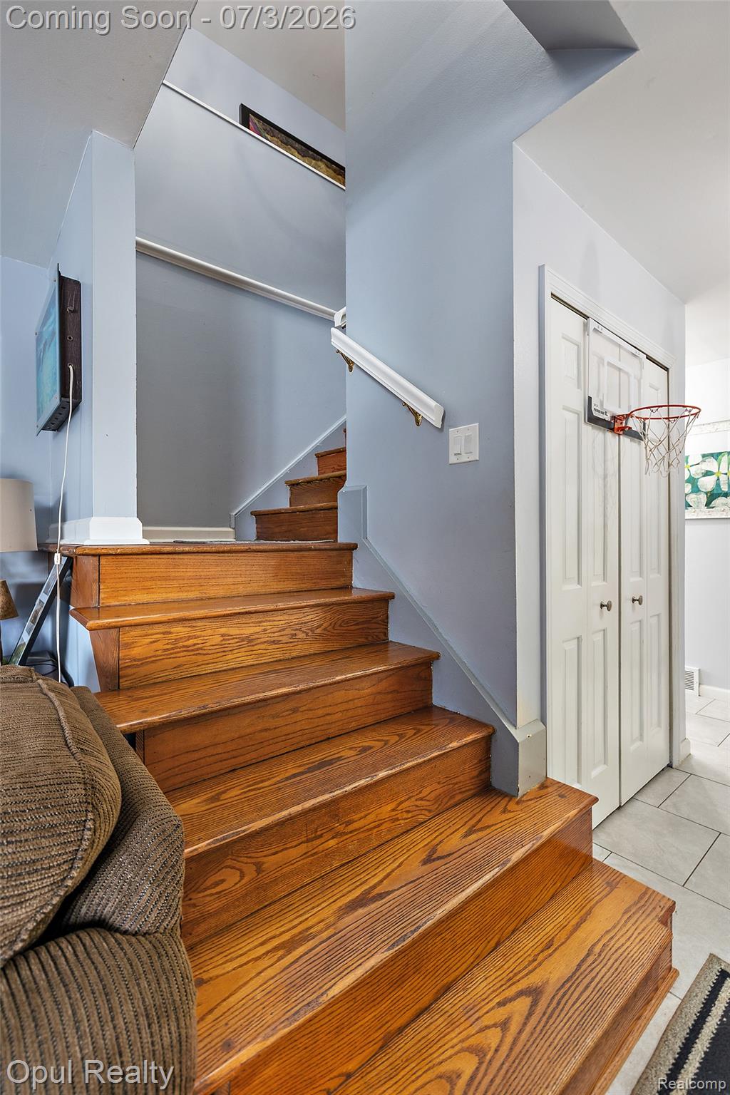 8855 Gross Road Dexter, MI 48130 - Photo 36 of 53 Hardwood staircase with white risers and handrail, complemented by light blue walls