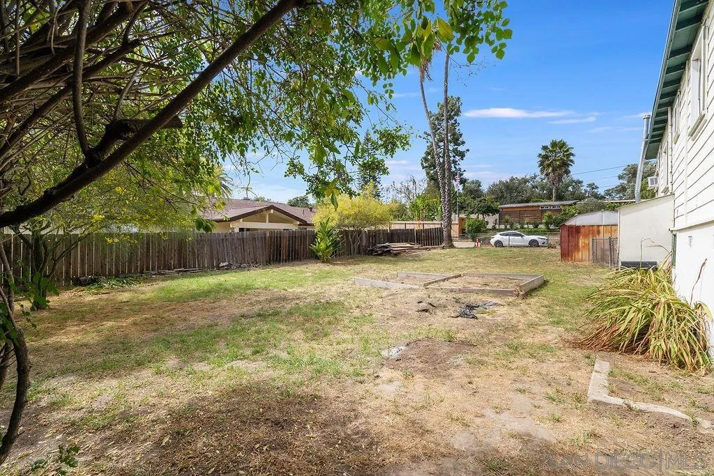 2924 Helix Street Spring Valley, CA 91977 - Photo 24 of 30 a backyard of a house with table and chairs under an umbrella