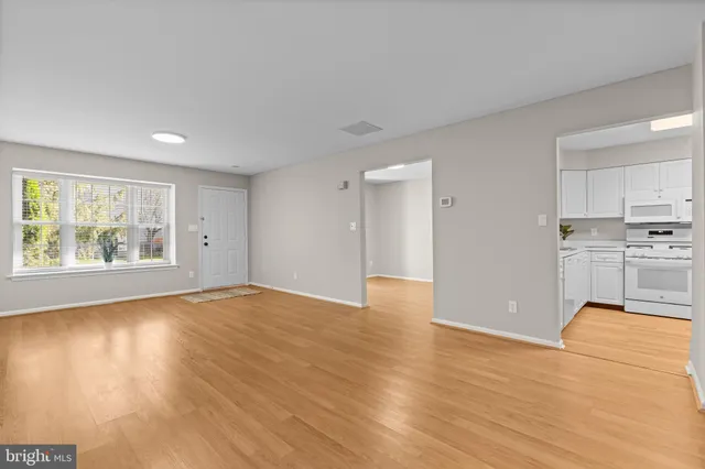 a view of empty room with wooden floor and window