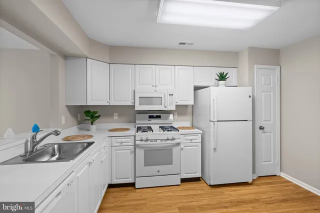 a kitchen with a white stove sink and refrigerator