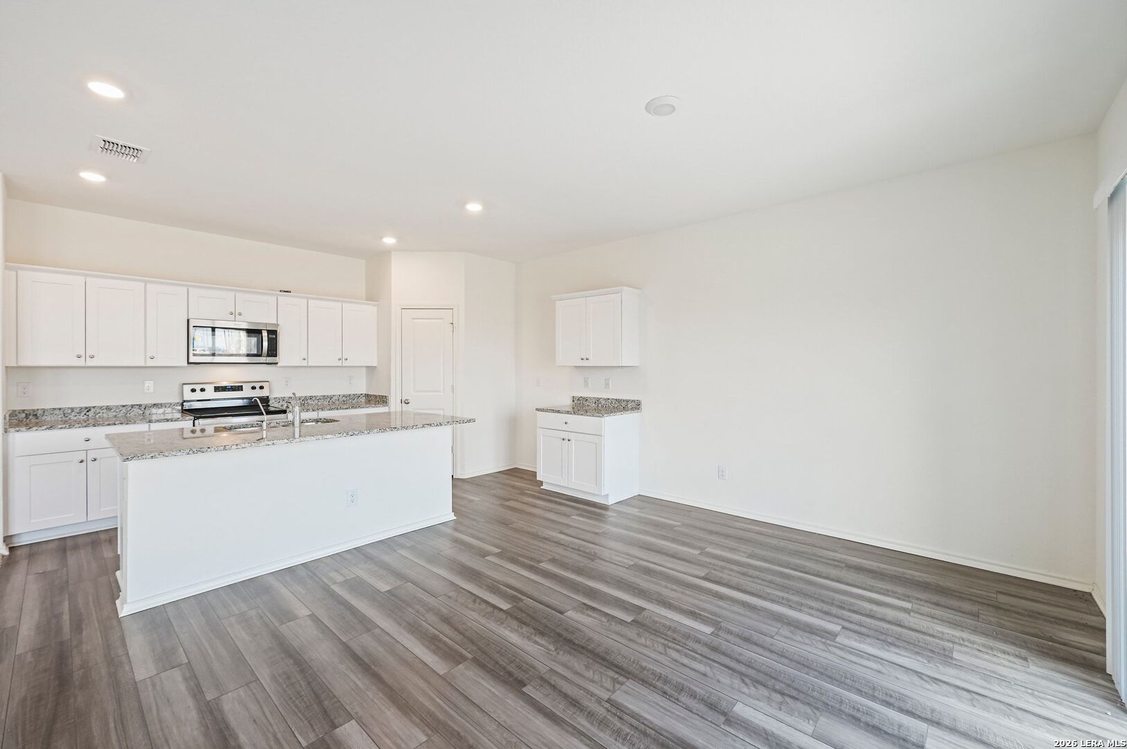 5535 Rue Girard Converse, TX 78109 - Photo 11 of 33 a kitchen with wooden floors and white cabinets