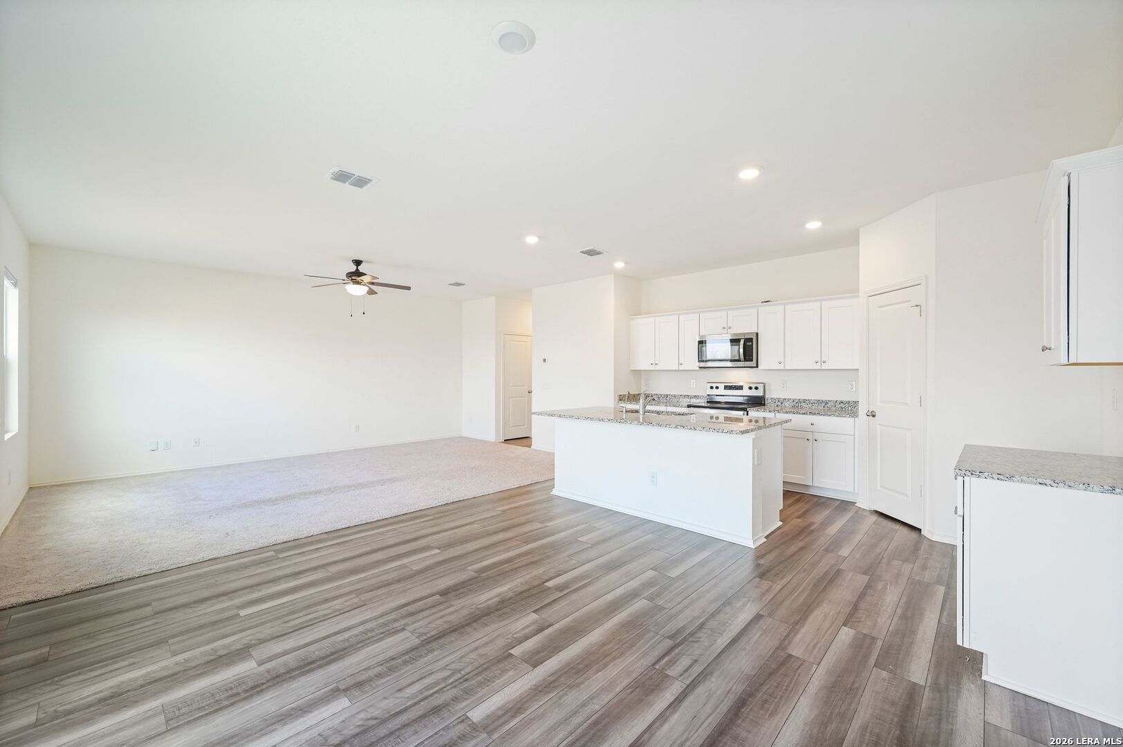 5535 Rue Girard Converse, TX 78109 - Photo 13 of 33 a large kitchen with kitchen island a sink stainless steel appliances and white cabinets