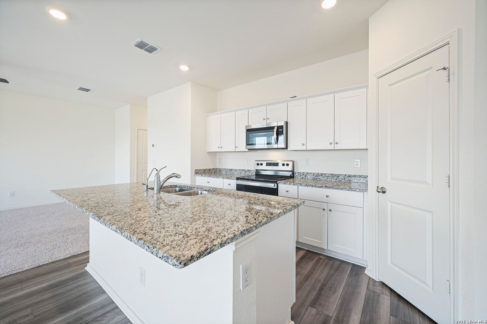 5535 Rue Girard Converse, TX 78109 - Photo 14 of 33 a kitchen with stainless steel appliances granite countertop a sink dishwasher and stove with white cabinets