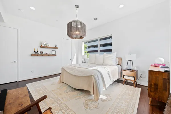 a bedroom with bed and wooden floor