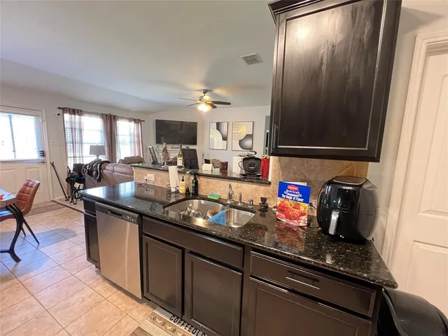 a kitchen with granite countertop a sink stove and cabinets