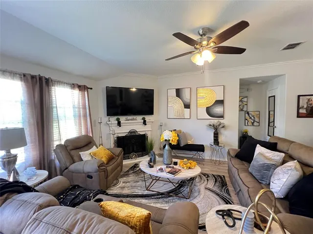 a living room with furniture a flat screen tv and a large window