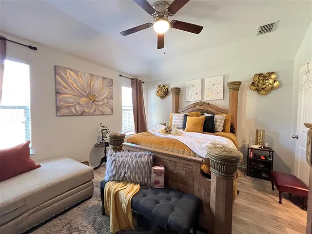 a bedroom with a bed and wooden floor