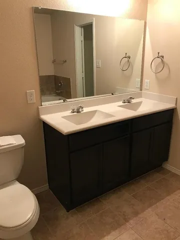 a bathroom with a toilet sink and mirror