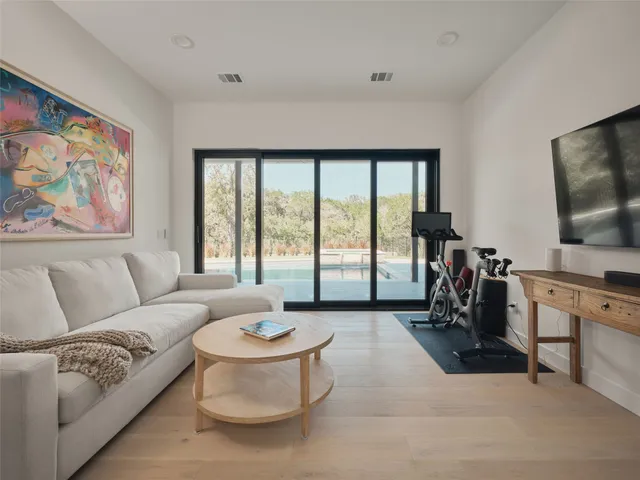 a living room with furniture a flat screen tv and a large window