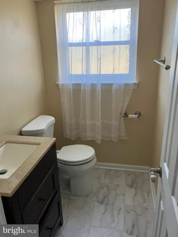 a bathroom with a sink a toilet and a window