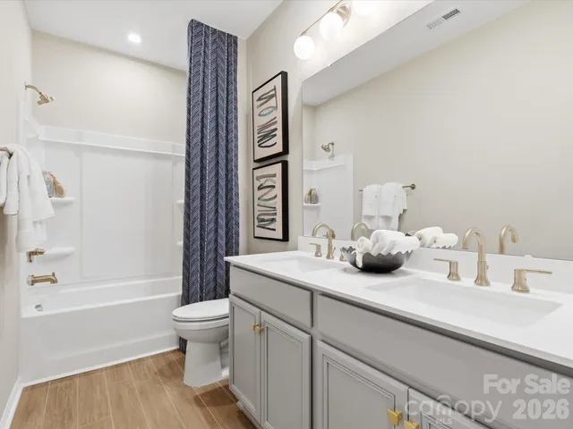 a bathroom with a granite countertop sink mirror vanity and toilet