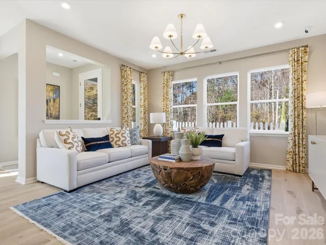 a living room with furniture and a chandelier