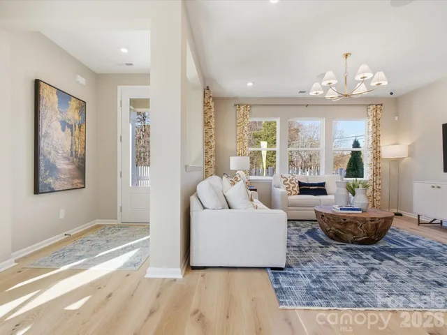 a living room with furniture and a chandelier