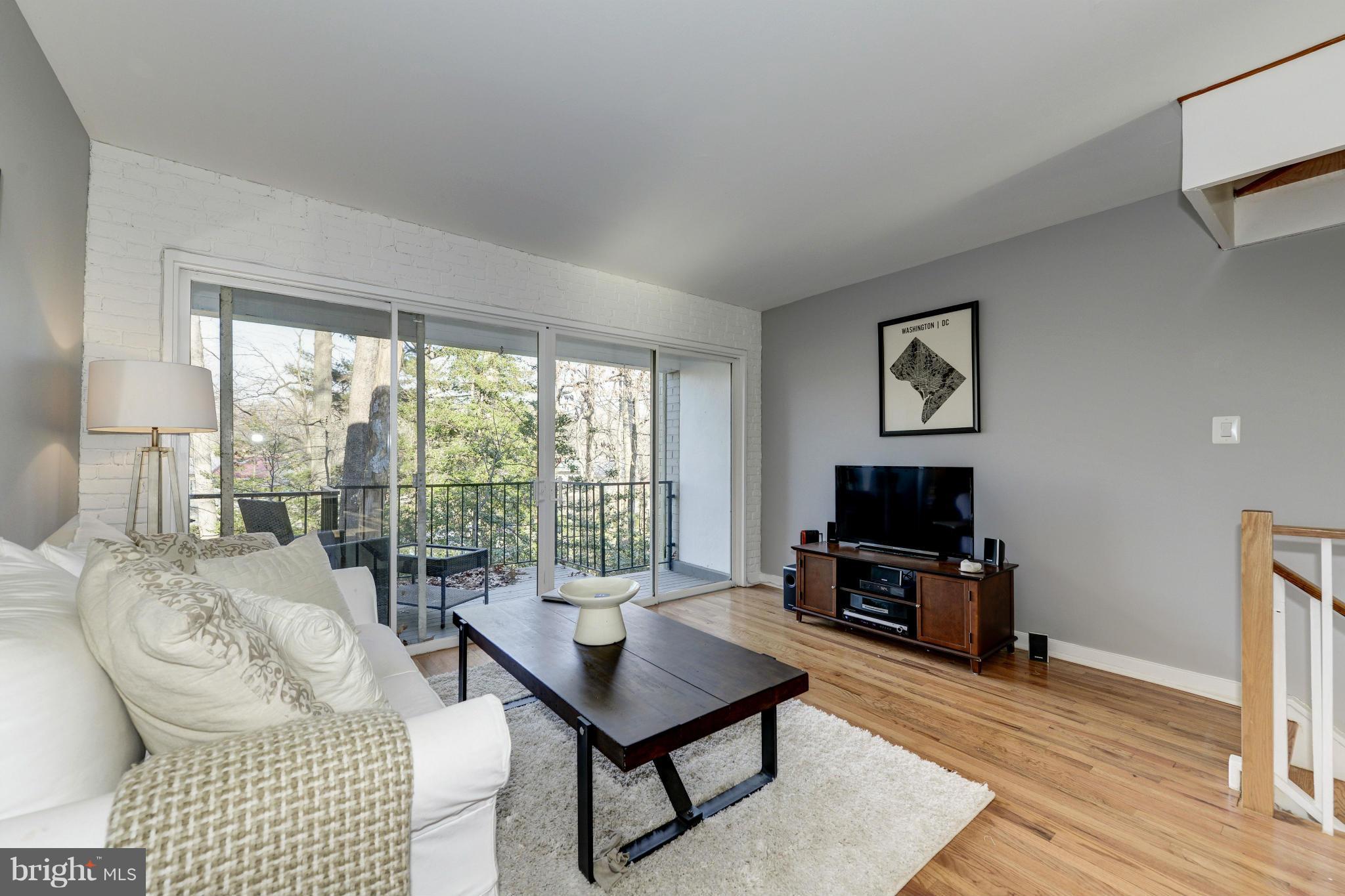 11475 Waterview Cluster Reston, VA 20190 - Photo 15 of 25 a living room with furniture a flat screen tv and a floor to ceiling window