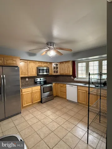 a large kitchen with a large counter top appliances and cabinets
