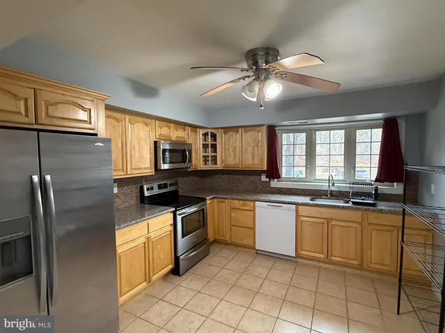 a kitchen with stainless steel appliances granite countertop a stove sink and cabinets