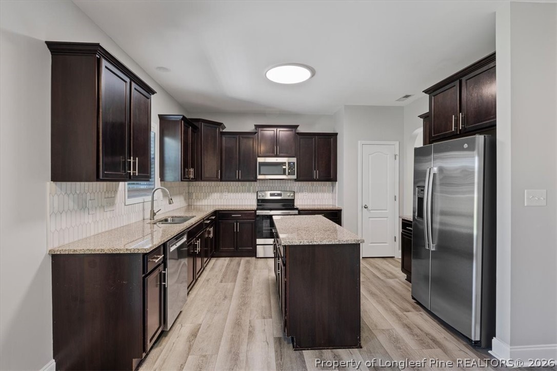 134 Huzzas Circle Cameron, NC 28326 - Photo 7 of 31 a kitchen with stainless steel appliances granite countertop a refrigerator a sink a stove a microwave and wooden cabinets