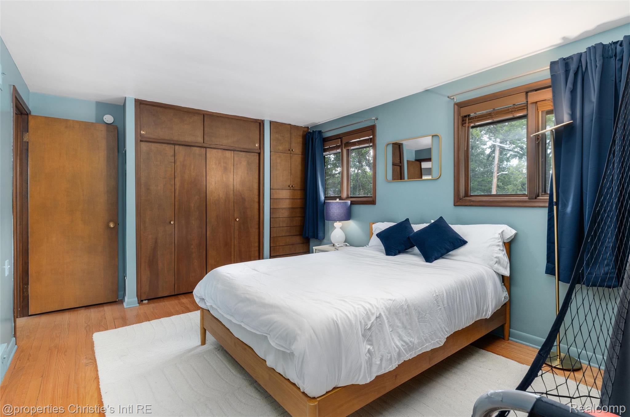 2771 West Seven Mile Road Detroit, MI 48221 - Photo 40 of 57 Room featuring wood-finish flooring, two windows with wood trim, and extensive built-in wooden cabinetry