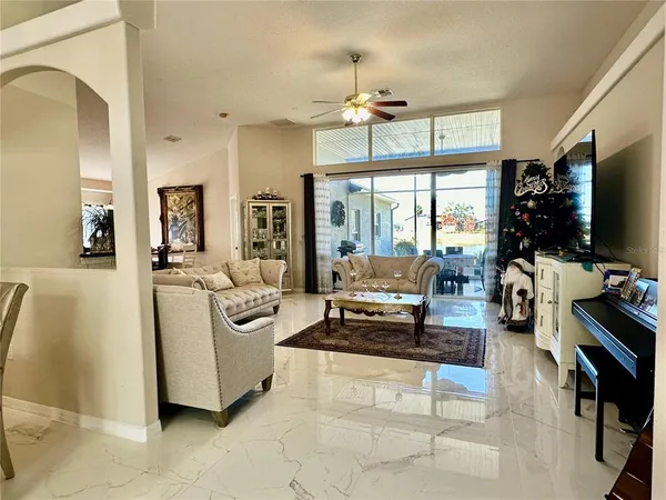 a living room with furniture a flat screen tv and a chandelier