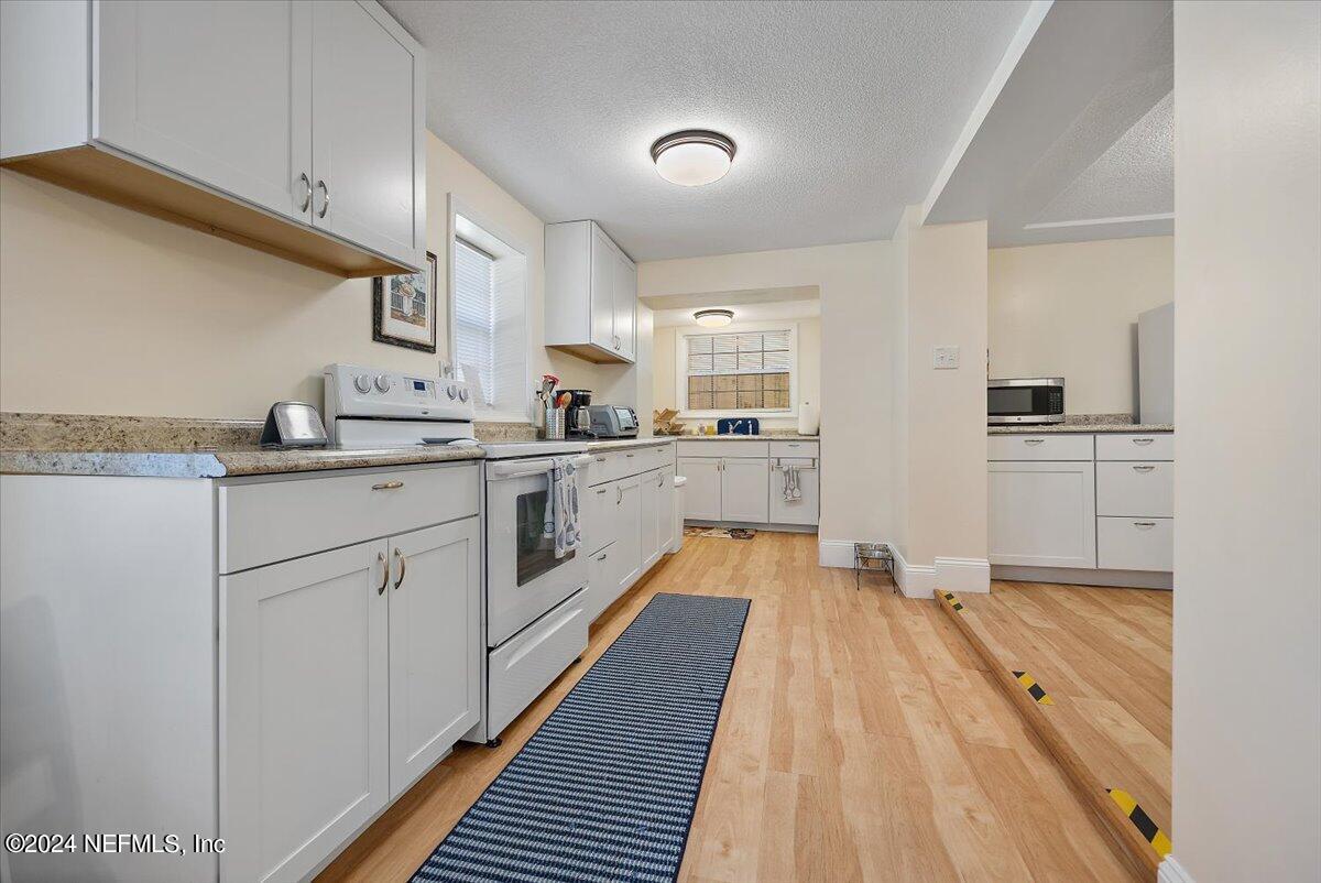 2610 Pacetti Road, Unit A St. Augustine, FL 32092 - Photo 10 of 31 a large kitchen with cabinets and wooden floor