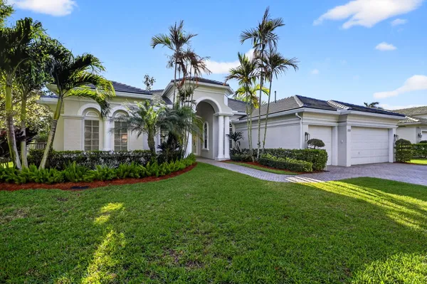 a view of a house with a big yard and large trees