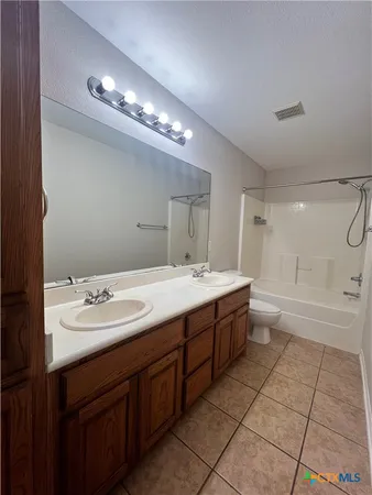 a spacious bathroom with a double vanity sink a mirror and a bathtub
