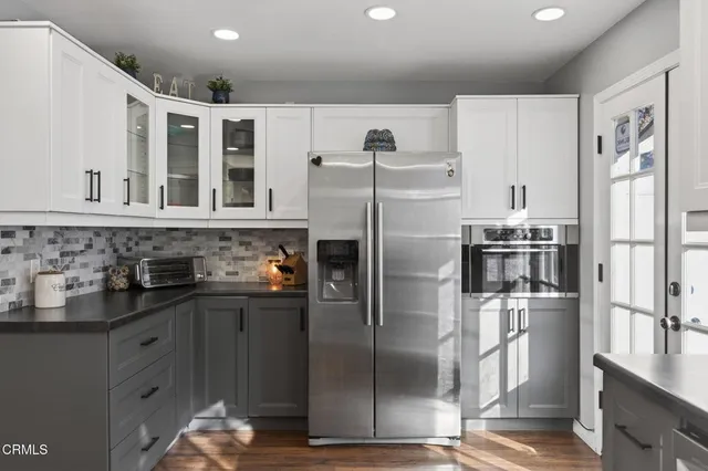 a kitchen with stainless steel appliances granite countertop a refrigerator and a sink