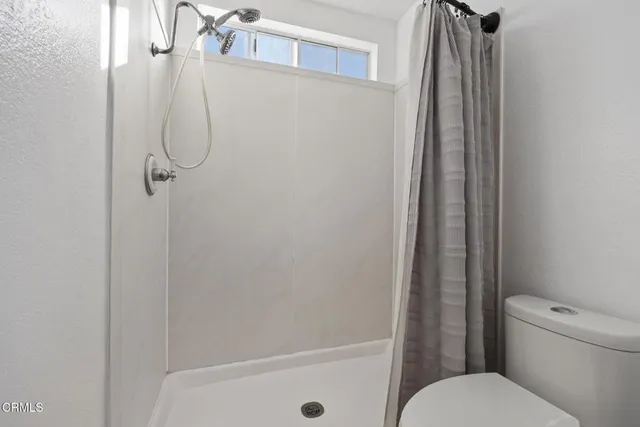 a bathroom with a shower and toilet