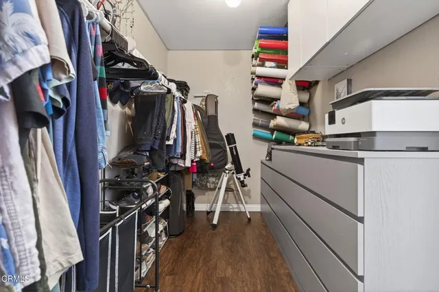 a view of walk in closet with clothes and shoes