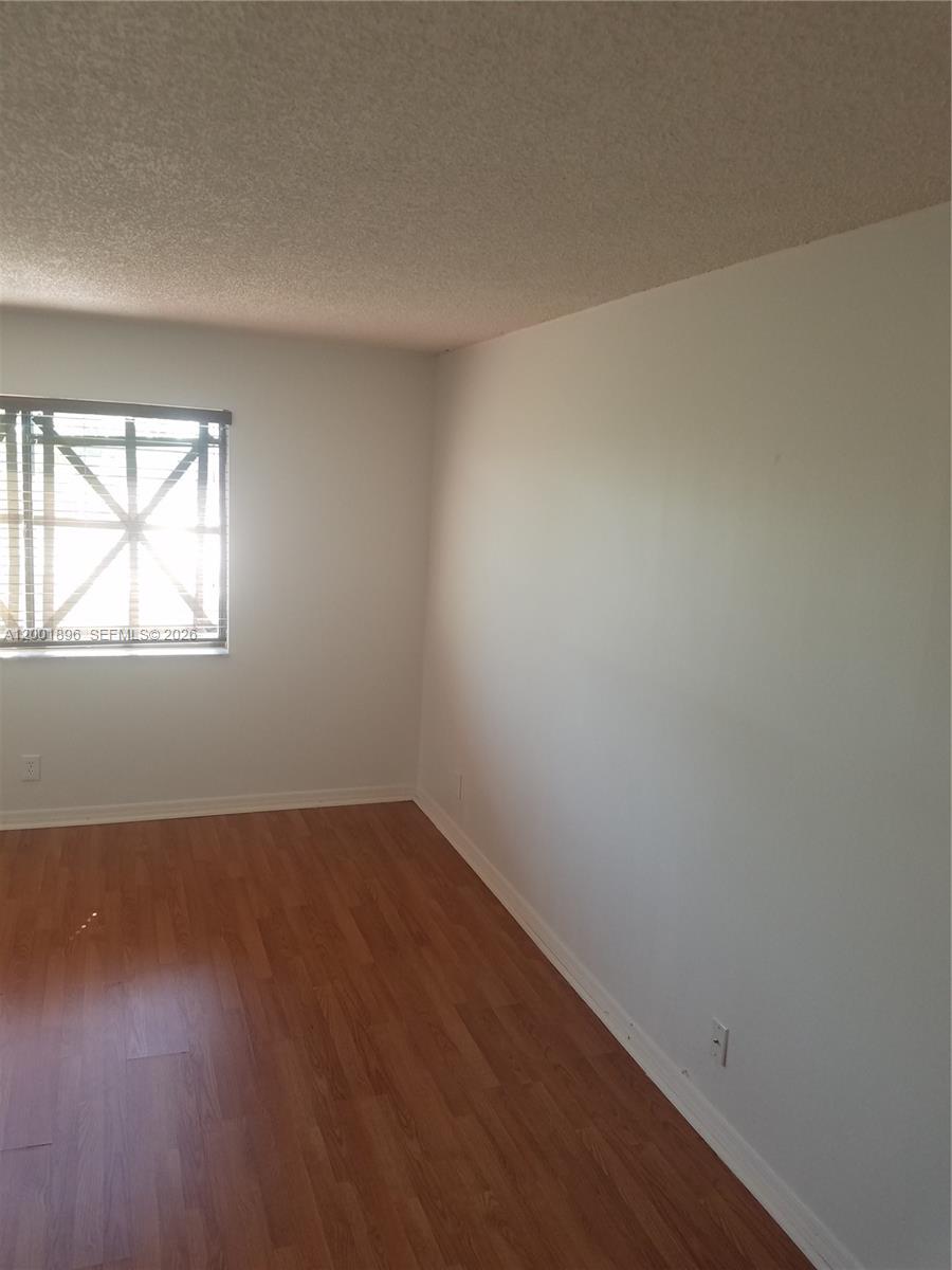 310 Racquet Club Road, Unit 204 Weston, FL 33326 - Photo 12 of 22 an empty room with wooden floor and windows