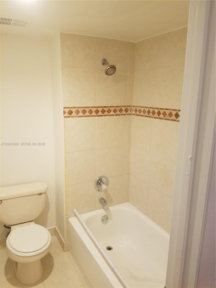 310 Racquet Club Road, Unit 204 Weston, FL 33326 - Photo 16 of 22 a white toilet sitting next to a bath tub