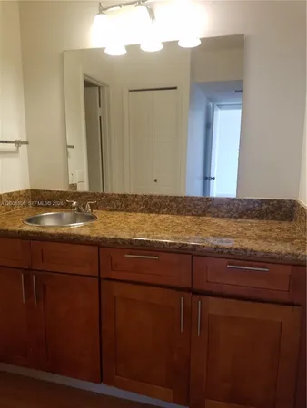 a view of kitchen with granite countertop cabinets and sink