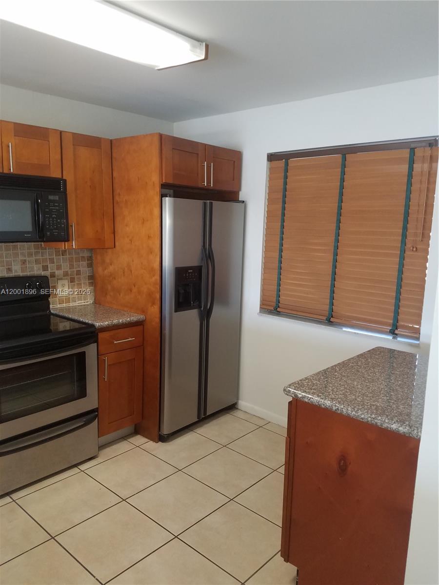 310 Racquet Club Road, Unit 204 Weston, FL 33326 - Photo 4 of 22 a kitchen with stainless steel appliances granite countertop a refrigerator and a stove