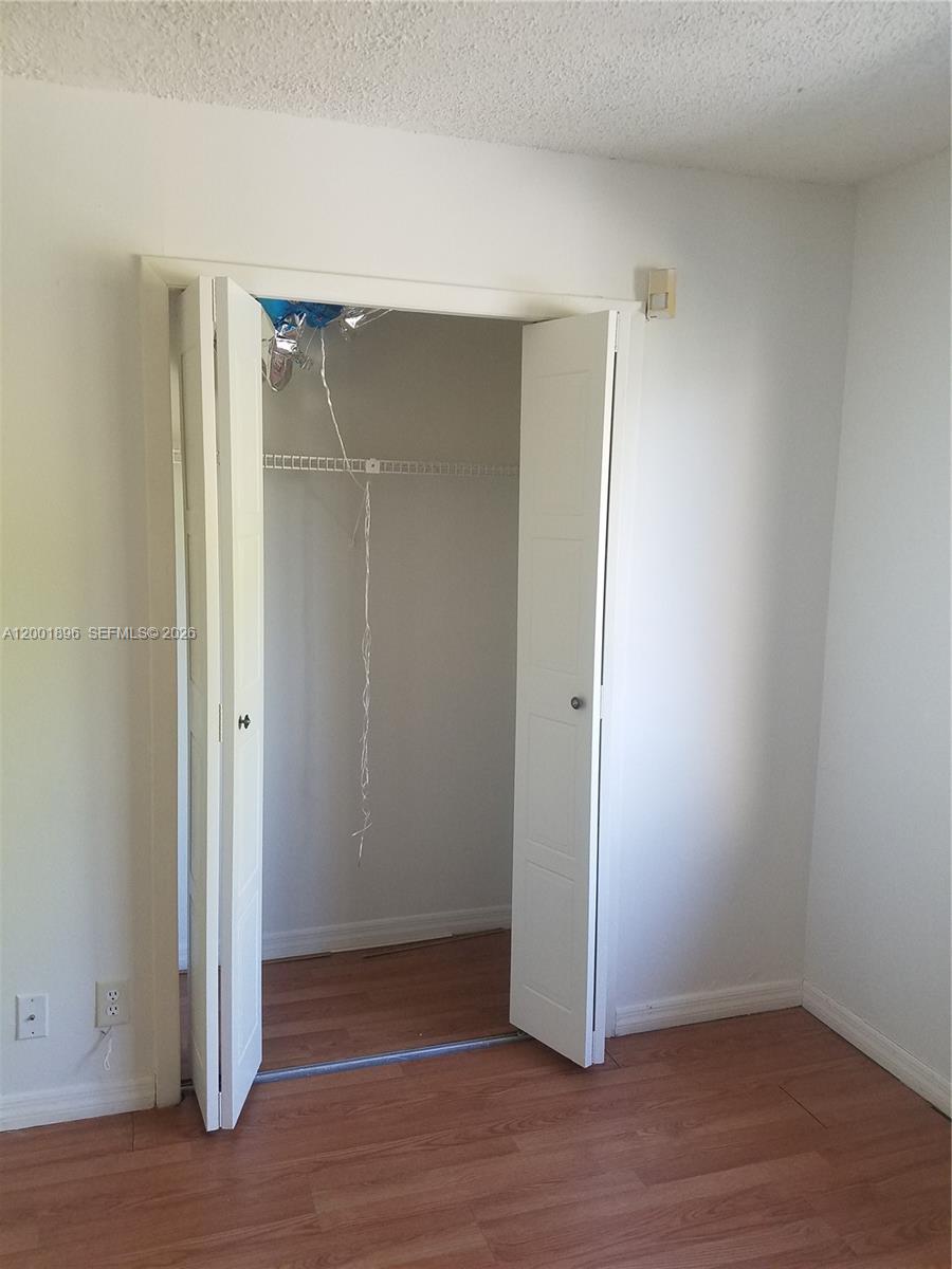 310 Racquet Club Road, Unit 204 Weston, FL 33326 - Photo 8 of 22 a view of an empty room with wooden floor and closet