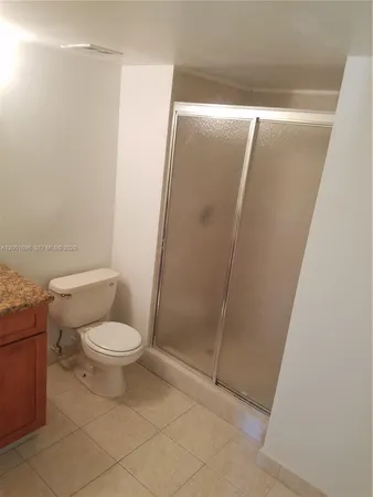 a white toilet sitting next to a shower